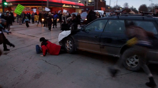 Um carro avançou contra manifestantes e atropelou uma mulher durante um protesto em Minneapolis em apoio à população de Ferguson nesta terça-feira (25) (Foto: The Star Tribune, Mark Vancleave/AP)
