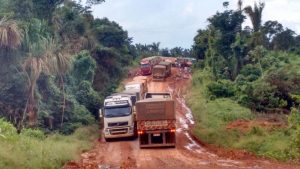 Caminhões esperam parados na rodovia para continuar à trafegar.