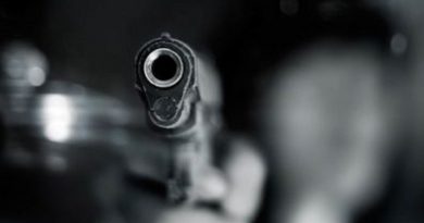 Black and white, woman pointing a old gun to front with one Hand on dark background