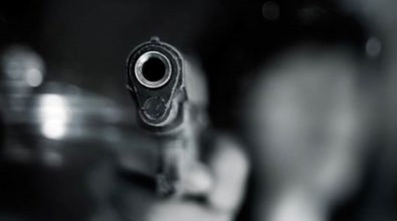 Black and white, woman pointing a old gun to front with one Hand on dark background