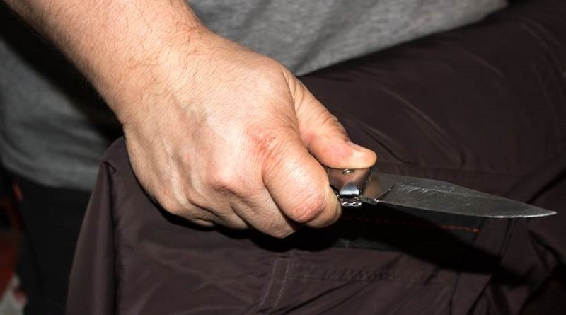 Closeup of a young man hand, holding a knife, about to attack,