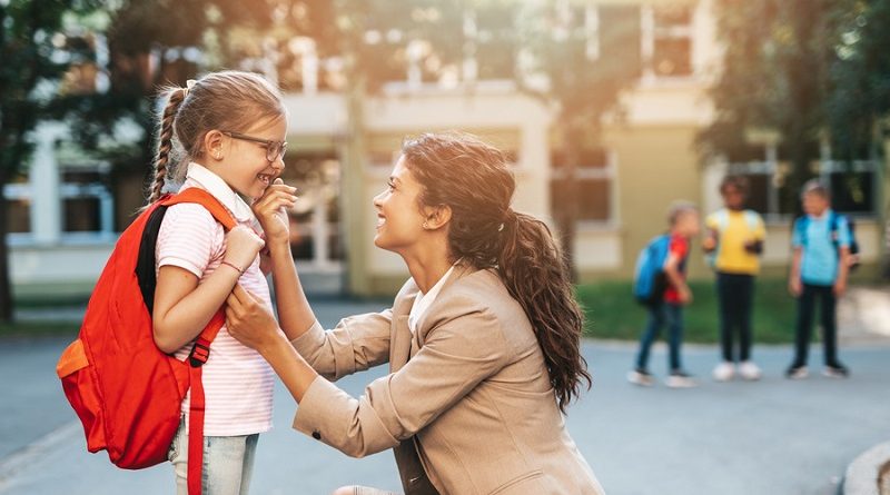First day at school. Mother leads a little child school girl in first grade.