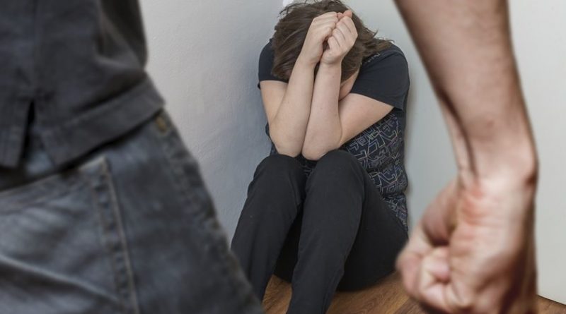 Fist of anger man and crying woman sitting in corner. Domestic violence and social concept.