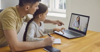 Online learning lessons education school. Father and daughter are doing online education with a teacher using a laptop sitting at a desk at home.