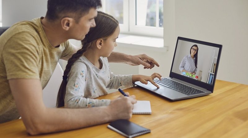 Online learning lessons education school. Father and daughter are doing online education with a teacher using a laptop sitting at a desk at home.