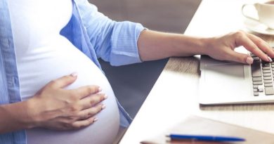 Cropped image of beautiful pregnant business woman using a laptop and holding one hand on her belly while working at home
