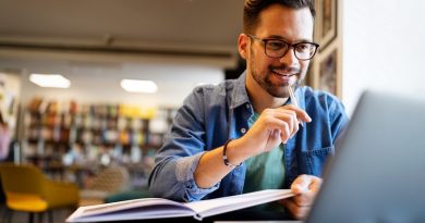 Smiling male student working and learning in a library