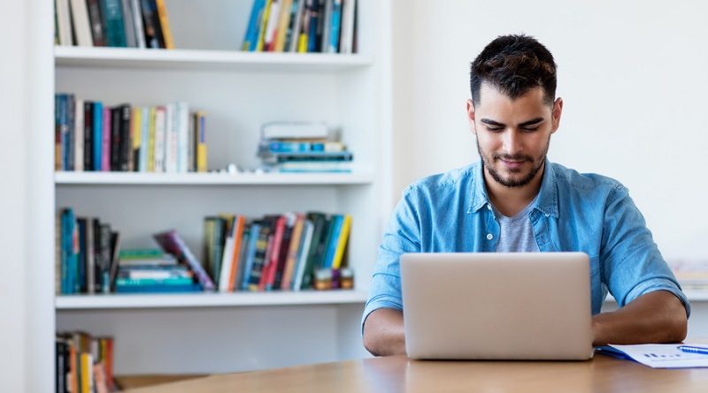 Mexican hipster man working with computer indoor at desk at home