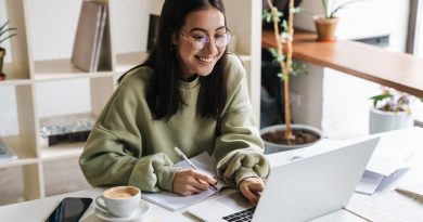 Image of a pretty positive optimistic young girl student using laptop computer indoors studying.