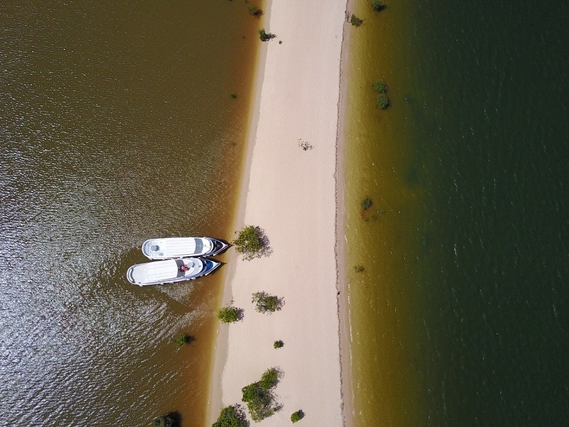 À esquerda, as águas com coloração amarronzadas se diferem da cor tradicional sem sedimentos do rio Tapajós, no lado direito. Foto: Julia Dolce
