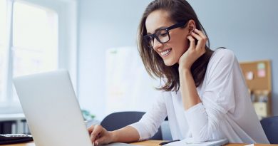 Portrait of veautiful cheerful young businesswoman working on laptop and laughing in home office