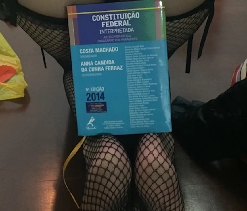 Mulher posa com livro sobre a Constituição com artigo do juiz Valmir Maurici Júnior — Foto: Reprodução