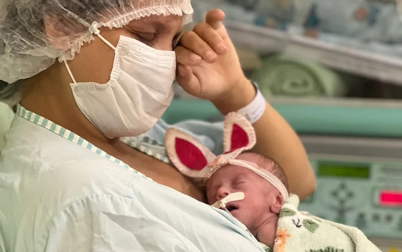 Luciane Cunha se emocionou ao segurar no colo a filha Paloma para fotos usando orelhinha de coelhos que ela mesmo produziu — Foto: Hospital Materno-Infantil de Barcarena (HMIB)/Reprodução 