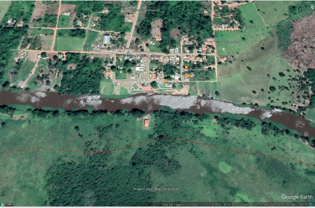 Imagem de satélite da base atacada, em frente ao rio São Miguel e ao distrito de Porto Murtinho. Na parte inferior da imagem, atrás da base, começa a área da Rebio Guaporé (linha vermelha). Fonte: Google Earth e ICMBio