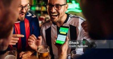 Soccer fans drinking beer at the pub and using mobile app for betting.