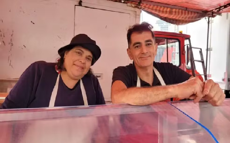 Os feirantes Rose Tragl e Sergio Silva dizem que reduziram a margem de lucro para não perder os clientes — Foto: BBC