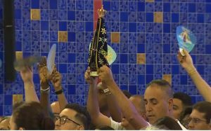 Devoto exibe imagem de Nossa Senhora Aparecida na missa solene — Foto: Carlinhos Brasil/TV Vanguarda