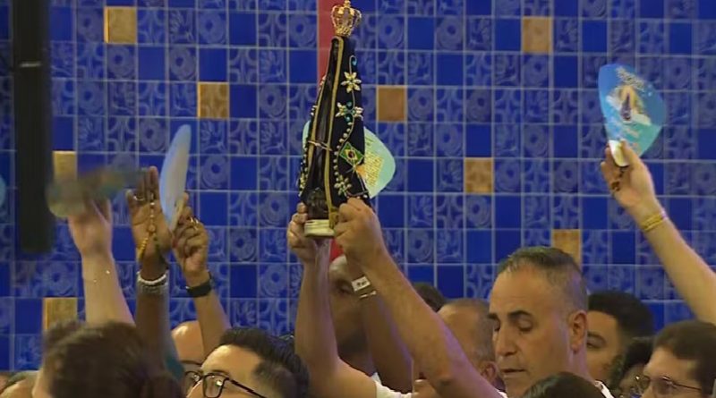 Devoto exibe imagem de Nossa Senhora Aparecida na missa solene — Foto: Carlinhos Brasil/TV Vanguarda